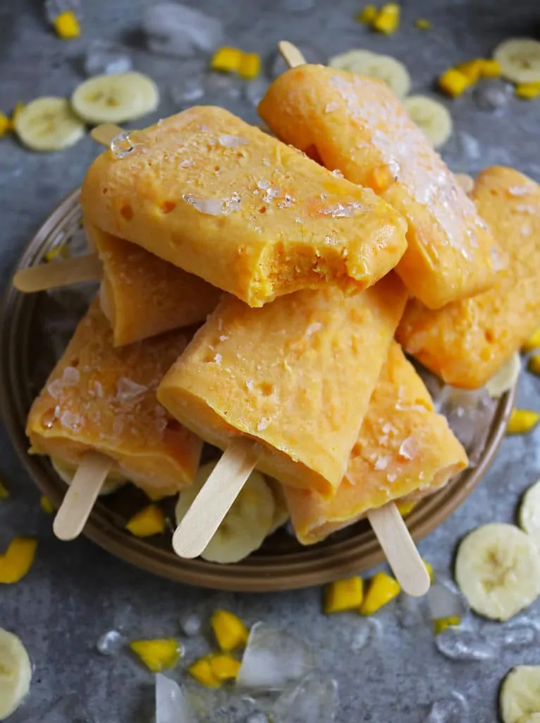 Bite of Mango And Banana Protein Popsicles on Plate