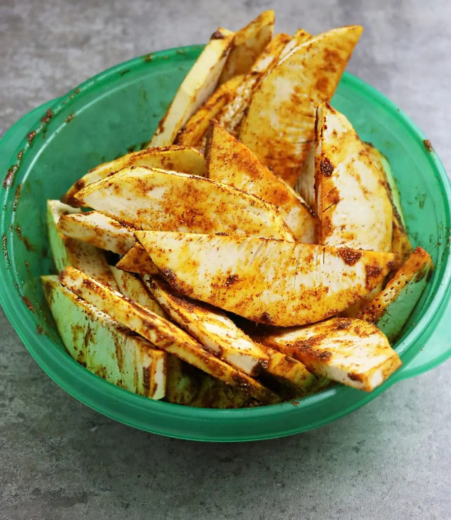 saturating breadfruit with spices to make breadfruit fries with.