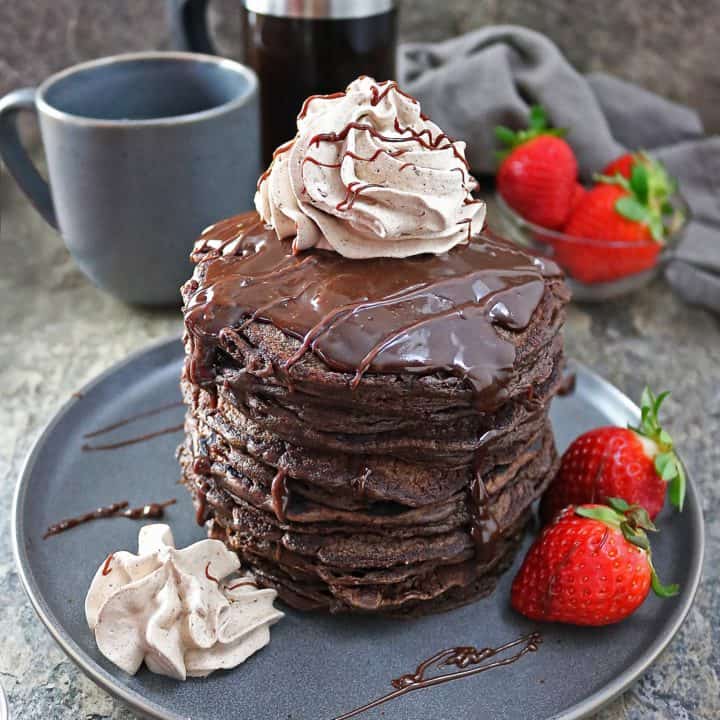 Stack of Easy Gluten Free Chocolate Oatmeal Pancakes with Chocolate sauce and chocolate whipped cream