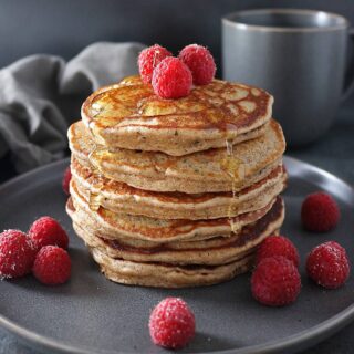 Stack of four Almond Hemp Pancakes with raspberries