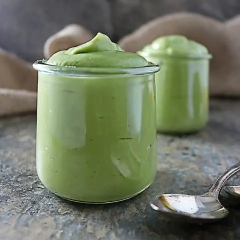 Photo with two glass pots of avocado pudding with spoons