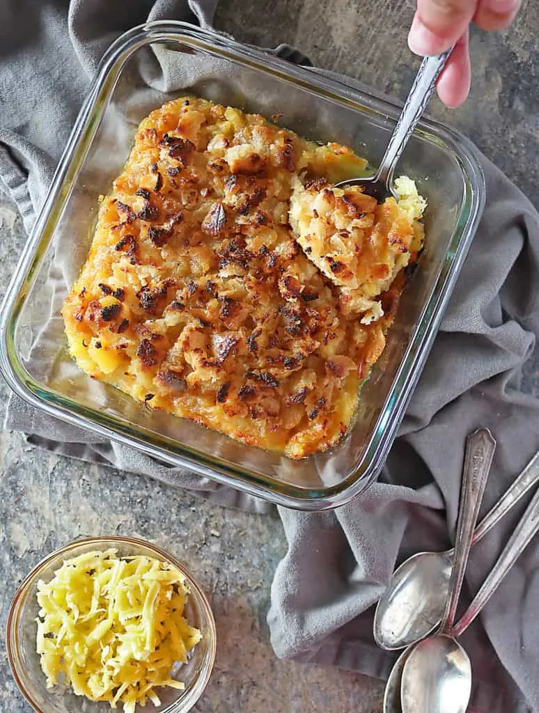 Photo of pineapple casserole with a spoonful being taken from it.