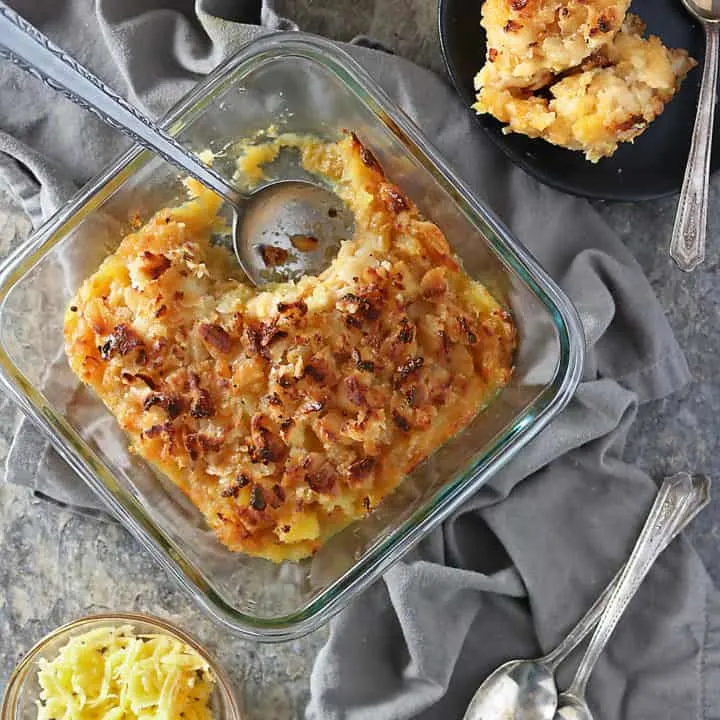 Overhead photo of plate with a scoop of pineapple casserole and glass container with remaining pineapple casserole in it.