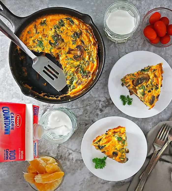 Skillet with Spinach Mushroom Bake and two plates with slices of it.