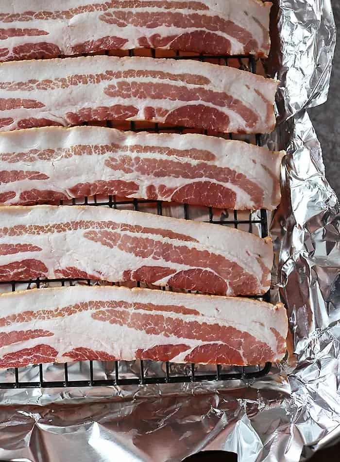 Photo of bacon on a iron raack ready to be baked