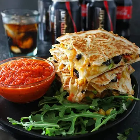 Photo of cheesy veggie quesadillas with roasted red pepper salsa and Coca-Cola in background