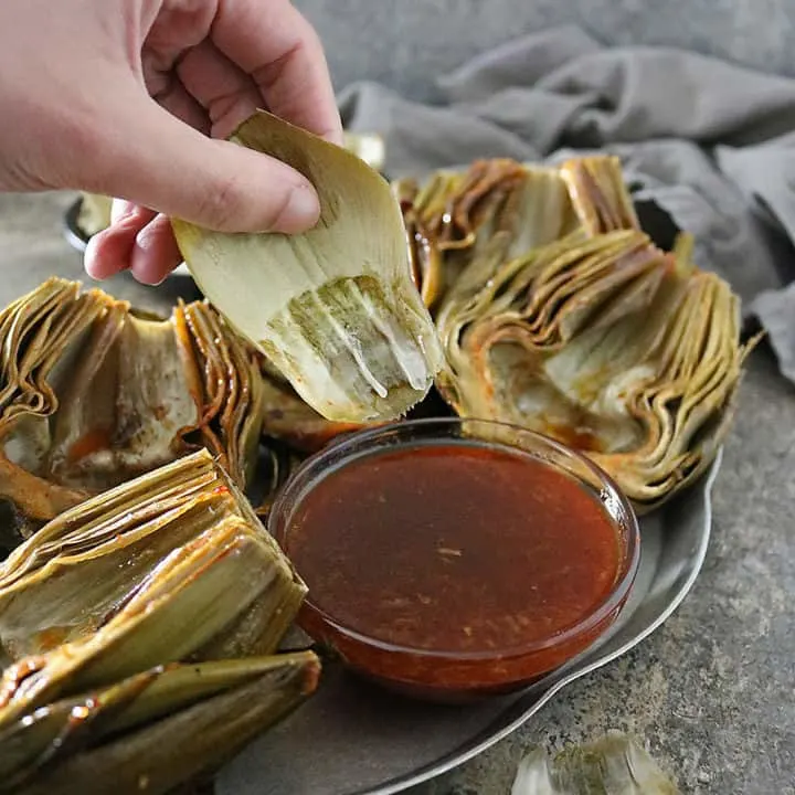 Delicious fresh artichokes are cleaned, trimmed, de-choked, and slathered with a tastebud tantalizing, Honey Orange Chili Sauce and oven roasted into a side your friends and family are so to get a kick out of!