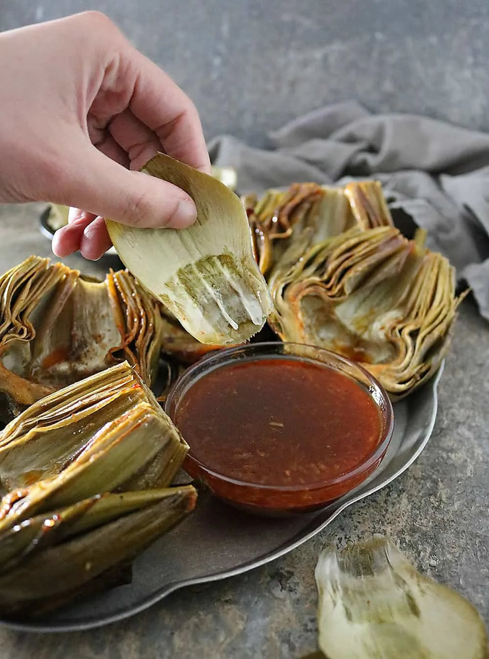 Delicious fresh artichokes are cleaned, trimmed, de-choked, and slathered with a tastebud tantalizing, Honey Orange Chili Sauce and oven roasted into a side your friends and family are so to get a kick out of!