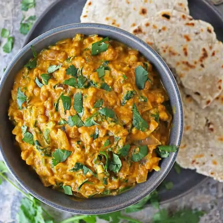 Easy vegan lentil curry in a bowl with Sri Lankan roti in a plate near by.