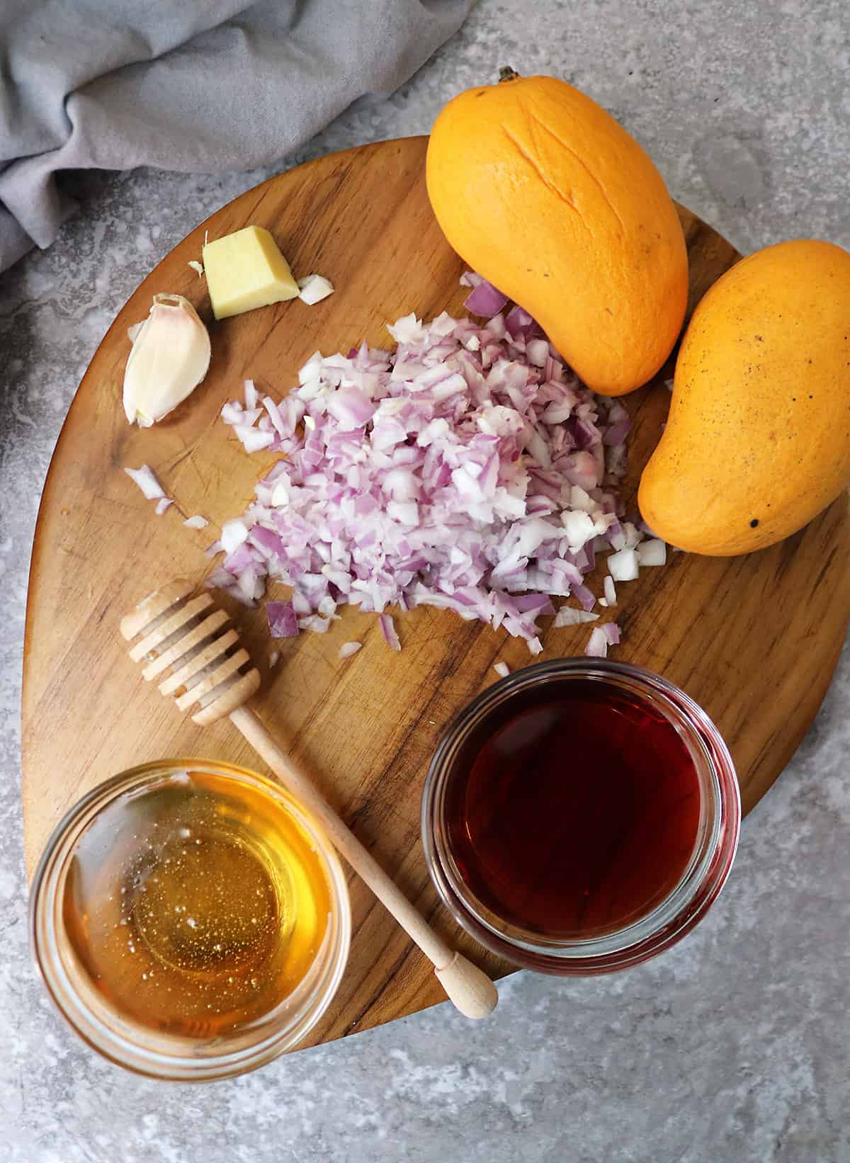 6 Ingredients to make mango chutney on a wood board.