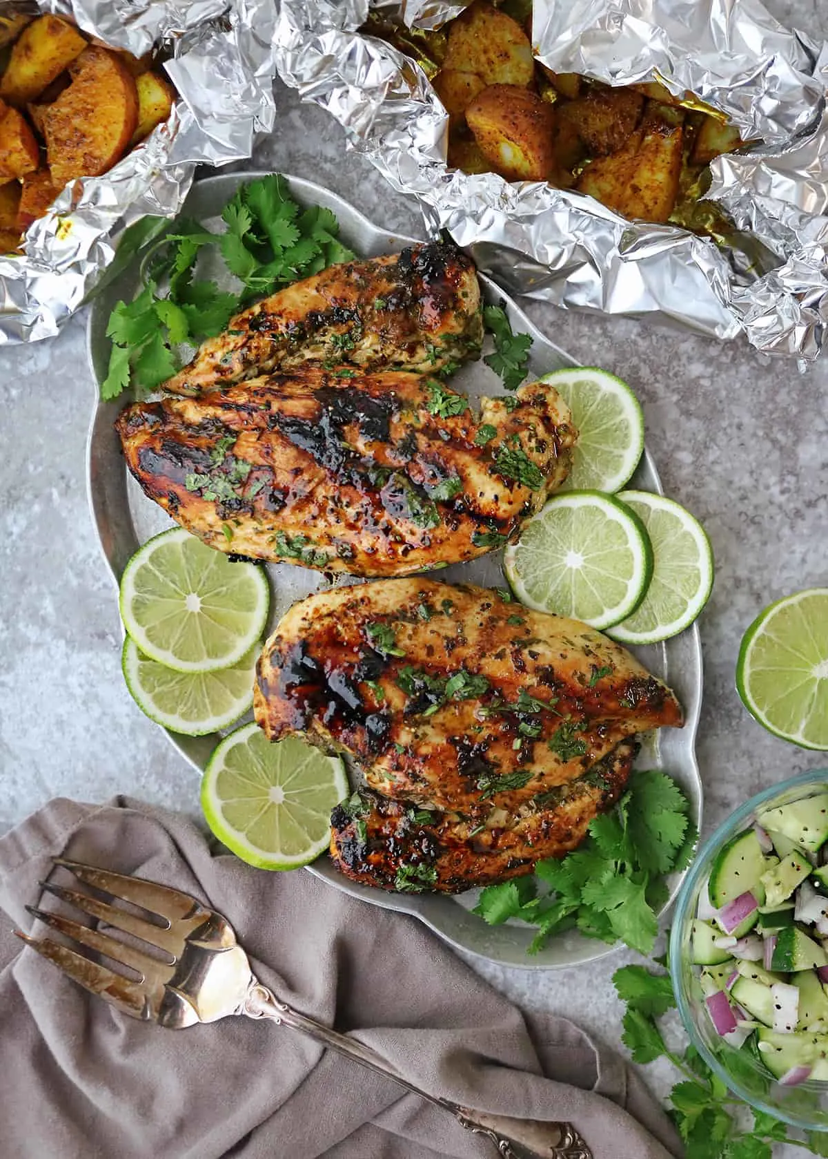 Table with Mouthwatering grilled cilantro lime chicken with turmeric potatoes and easy cucumber salad