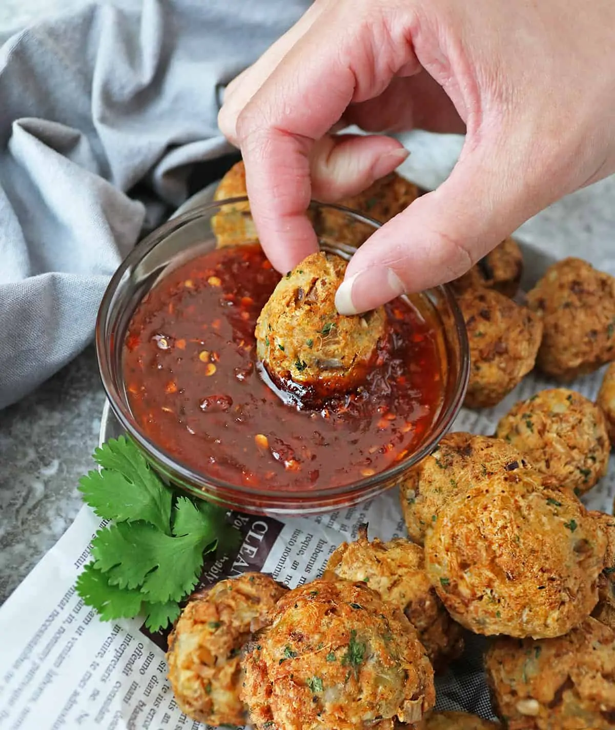 Air fryer salmon croquettes dipped into sweet chili sauce.
