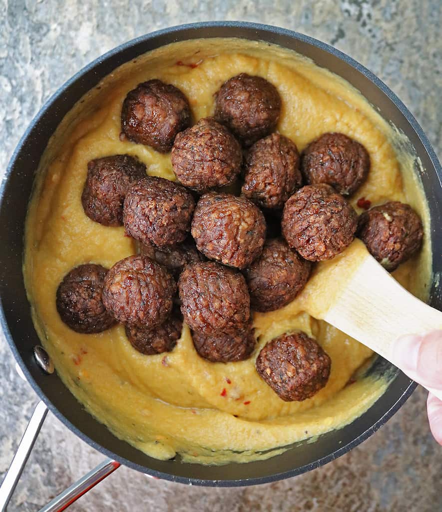 Adding meatless meatballs to delicious spicy cauliflower sauce