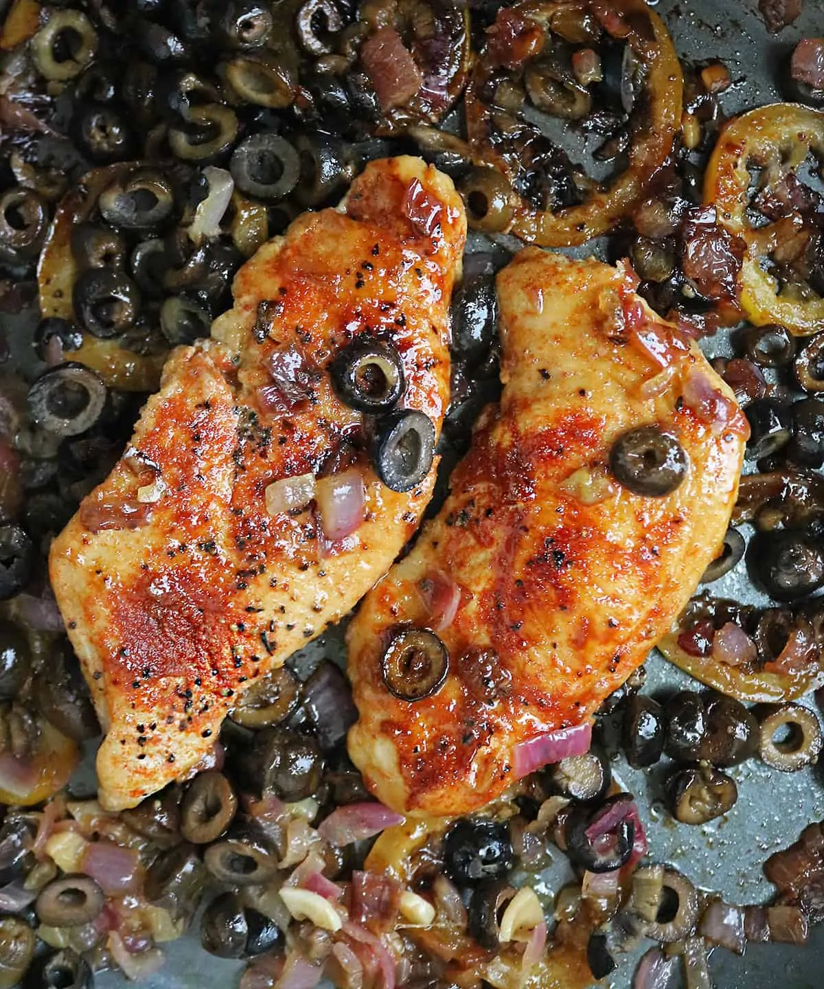 Delicious honey lemon chicken sauteing in pan with olives and caramelize lemon slices