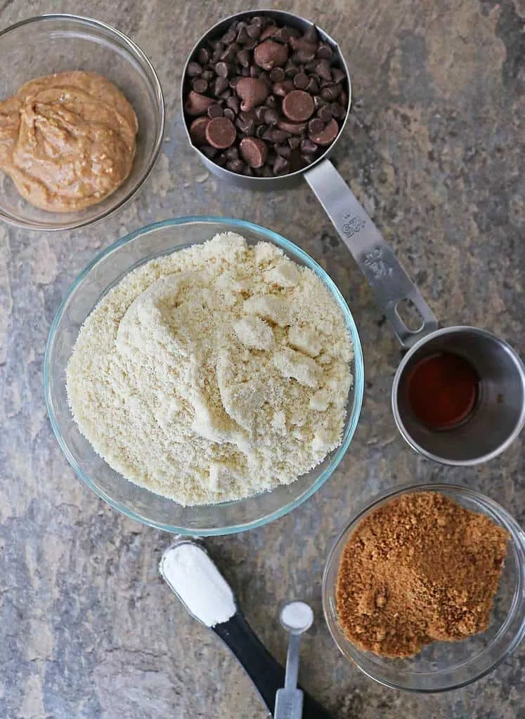 Ingredients to make almond chocolate-chip cookies in a flat lay