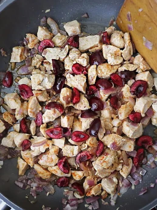 Sauteing Chicken With Cherries in a pan.