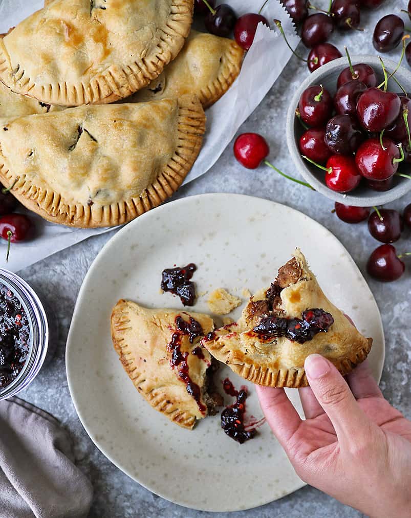 hand reaching for Tasty cherry hand pies with chicken and cherry chili sauce