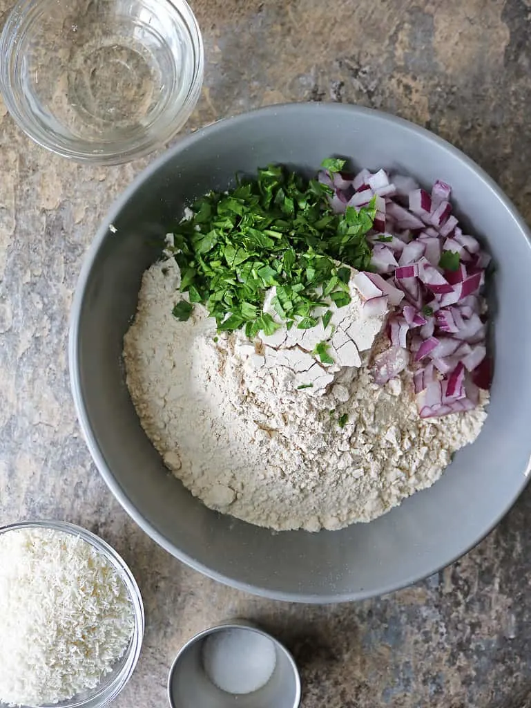 overhead photo of 7 ingredients to make pol roti with onion and herbs.