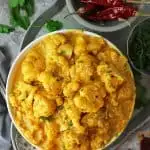 Bowl of Pumpkin Cauliflower Curry with cilantro and chili add ins.