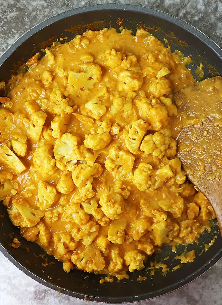 Making Cauliflower Pumpkin Curry in a large pan.