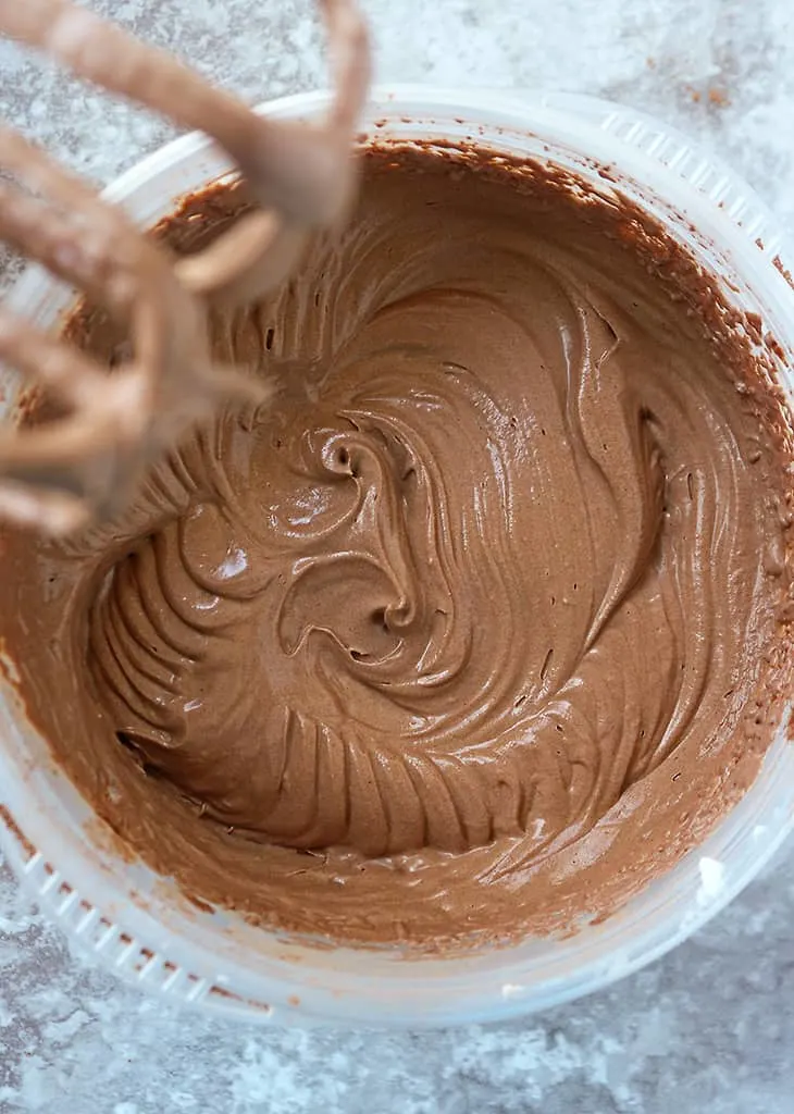 Using an electric mixer to mix the ingredients for this vegan chocolate ice cream.