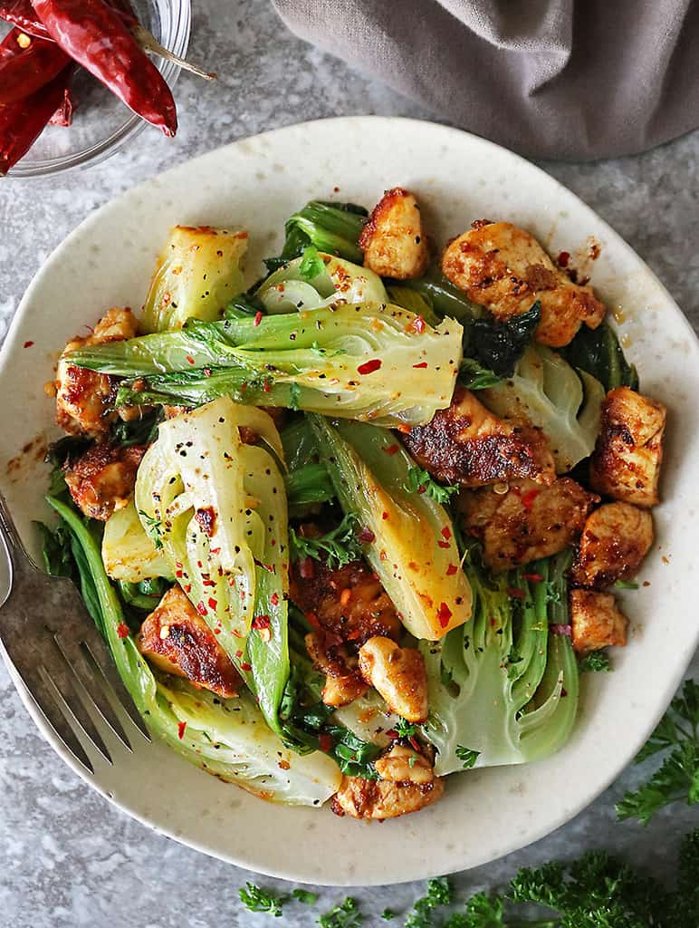 the best chicken and baby bok choy recipe on a plate with fork - ready for dinner.