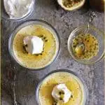 Two bowls with dairy-free, egg-free Passion Fruit Mousse in them with coconut whipped cream and sweetened passion fruit pulp.