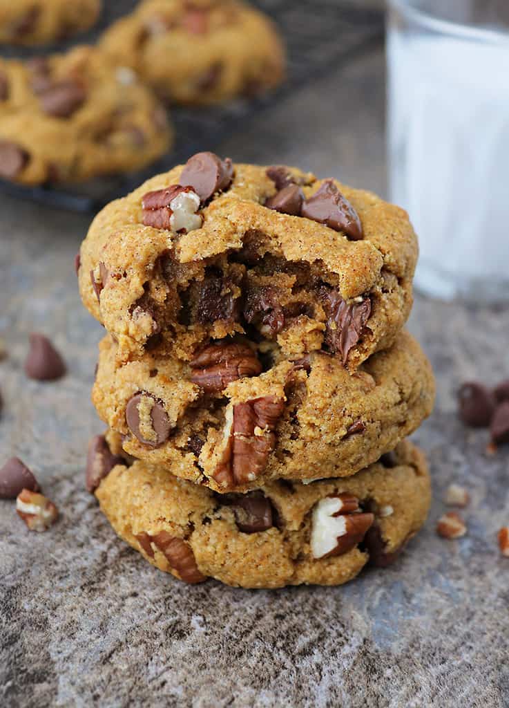 3 Easy pumpkin chocolate chip cookieswith a bite taken out of one and a glass of cold milk in the background.