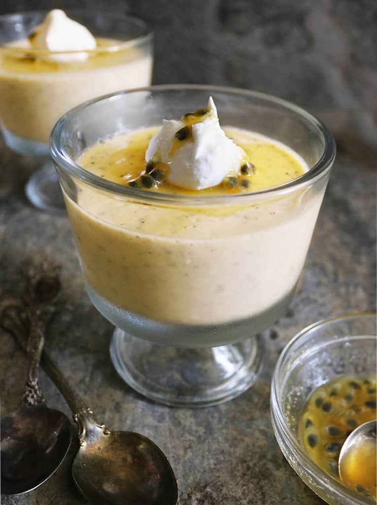 Vegan passion fruit pudding in two glass serving bowls - chilled and ready to enjoy.