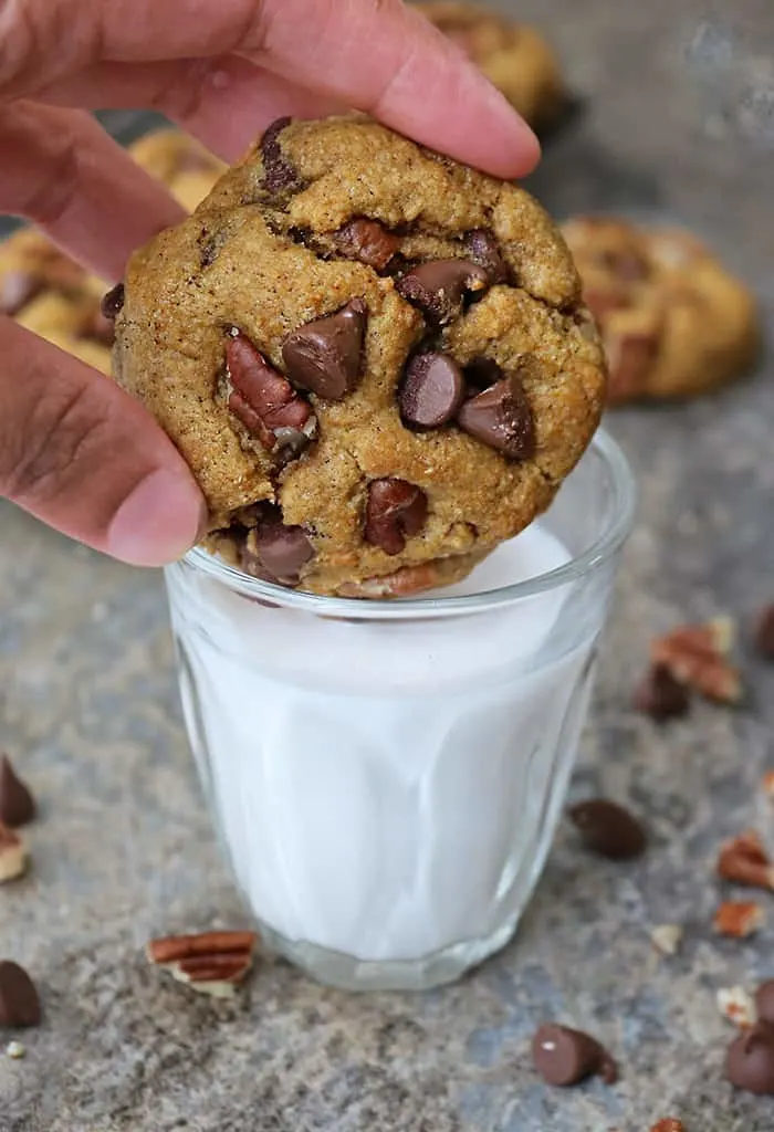 dipping one of these eggfree soft pumpkin chocolate chip cookies into a glass of milk.