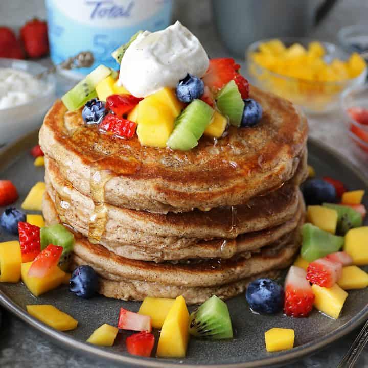 stack of gluten free yogurt pancakes with yogurt topping and fruit and FAGE.