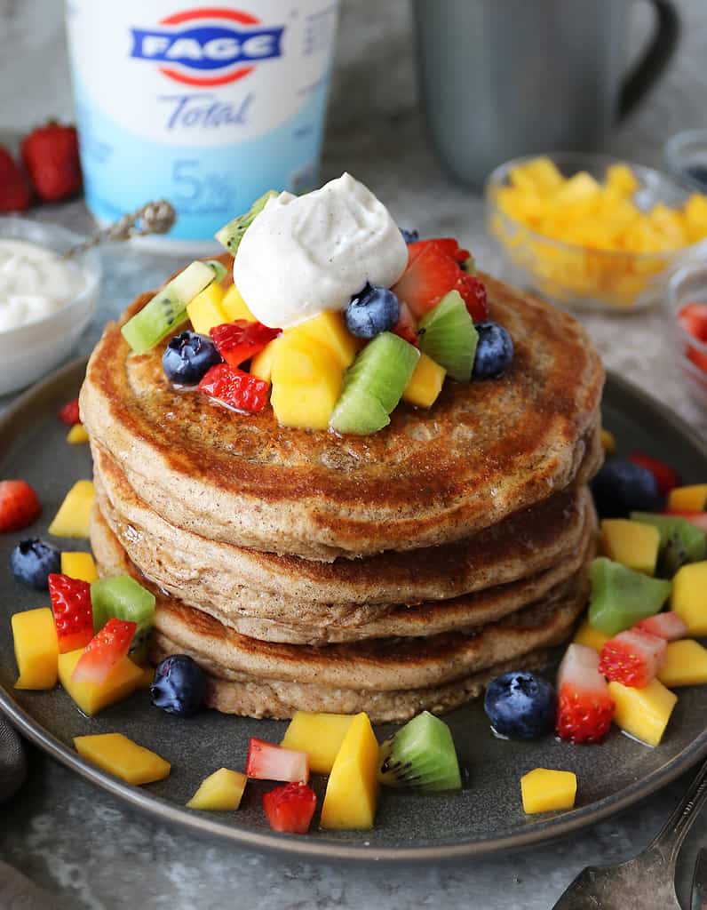 stack of gluten free yogurt pancakes with fruit and Greek yogurt.