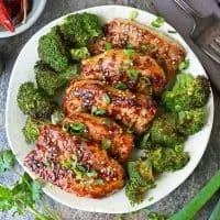 Boneless pork chops are pan sautéed and encased in a delicious ginger glaze and served on a plate.