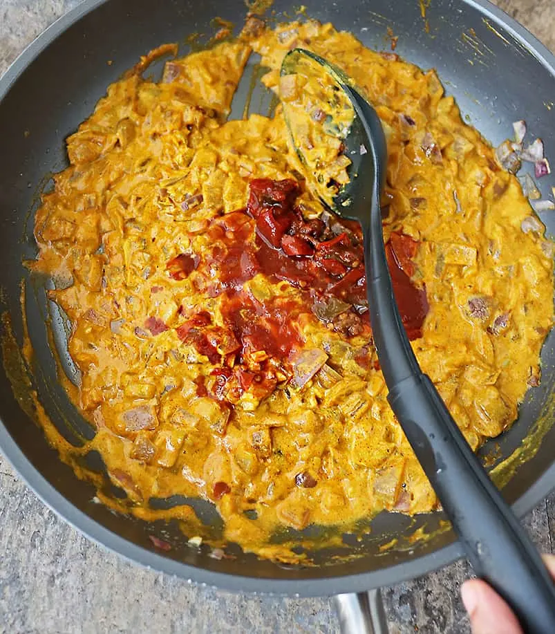 adding in chipotle peppers to make shrimp curry