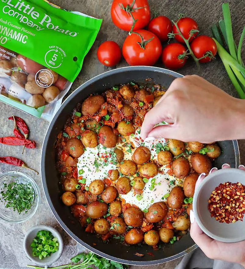 Garnishing potato shakshuka made with Little Potato Company Dynamic Dou Potatoes