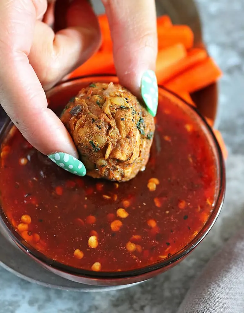 Enjoying plant-based jackfruit balls with sweet chili sauce.