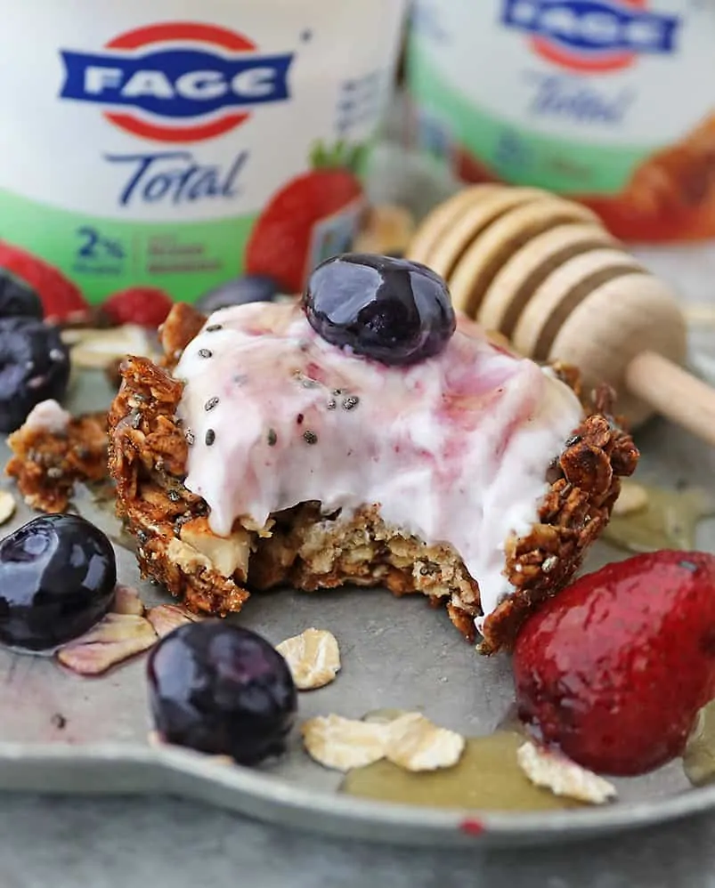 taking a bite of Delicious granola Greek Yogurt cups