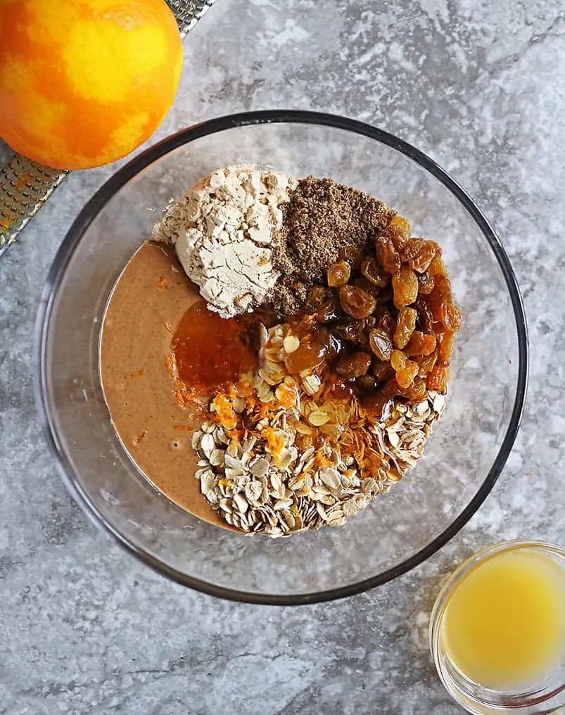 Ingredients to make Orange Protein Energy Balls in a glass bowl.