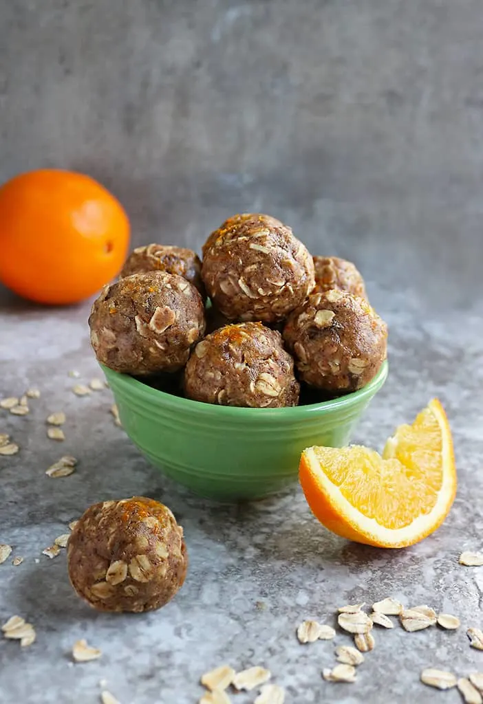 Green bowl with Orange Protein Energy Balls in it.