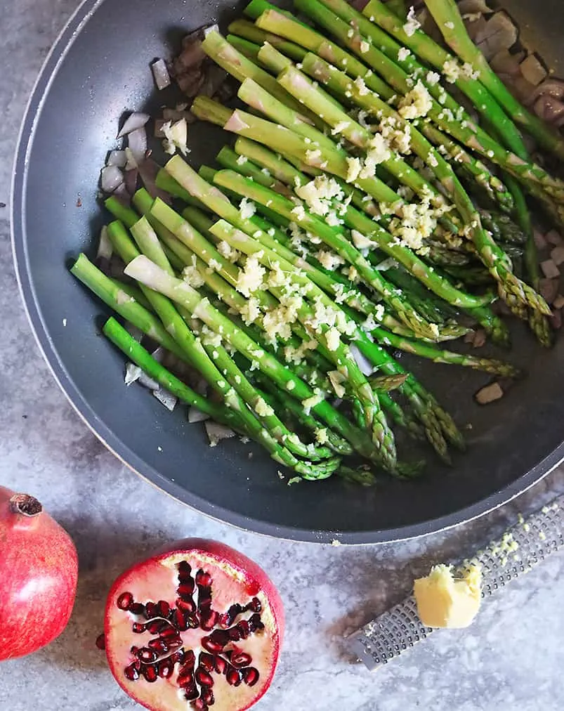 Sauteing asparagus garlic ginger to make Zataar Asparagus with Pomegranate