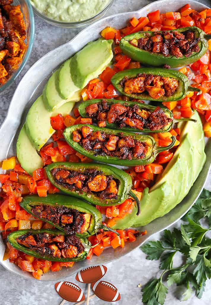 Tasty Easy Keto Stuffed Jalapenos placed on a platter with sauteed bell peppers