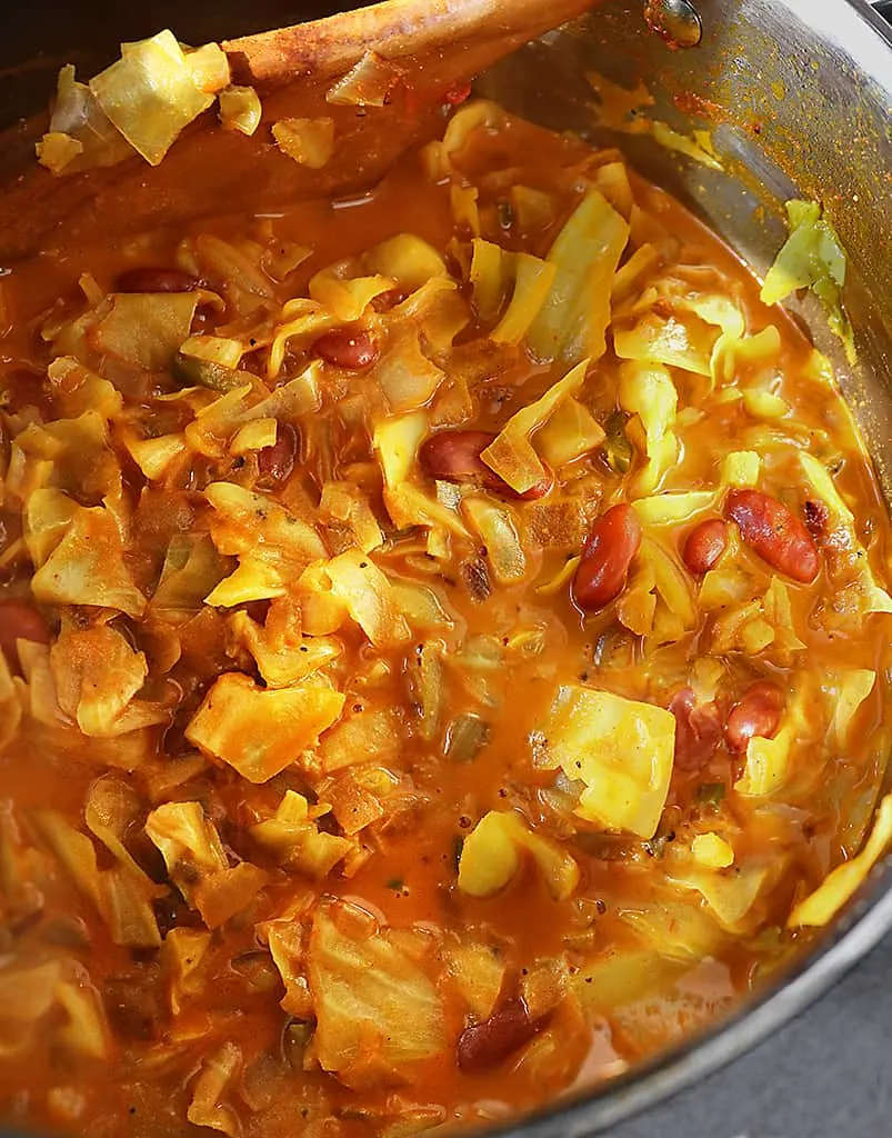 Tender cabbage cooking in a saucepan with a delicious tomato coconut broth