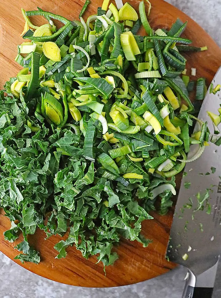 cutting bpard with  kale and leeks to make Colcannon Irish Mashed Potatoes