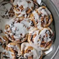 Baking tray with just iced cinnamon rolls.