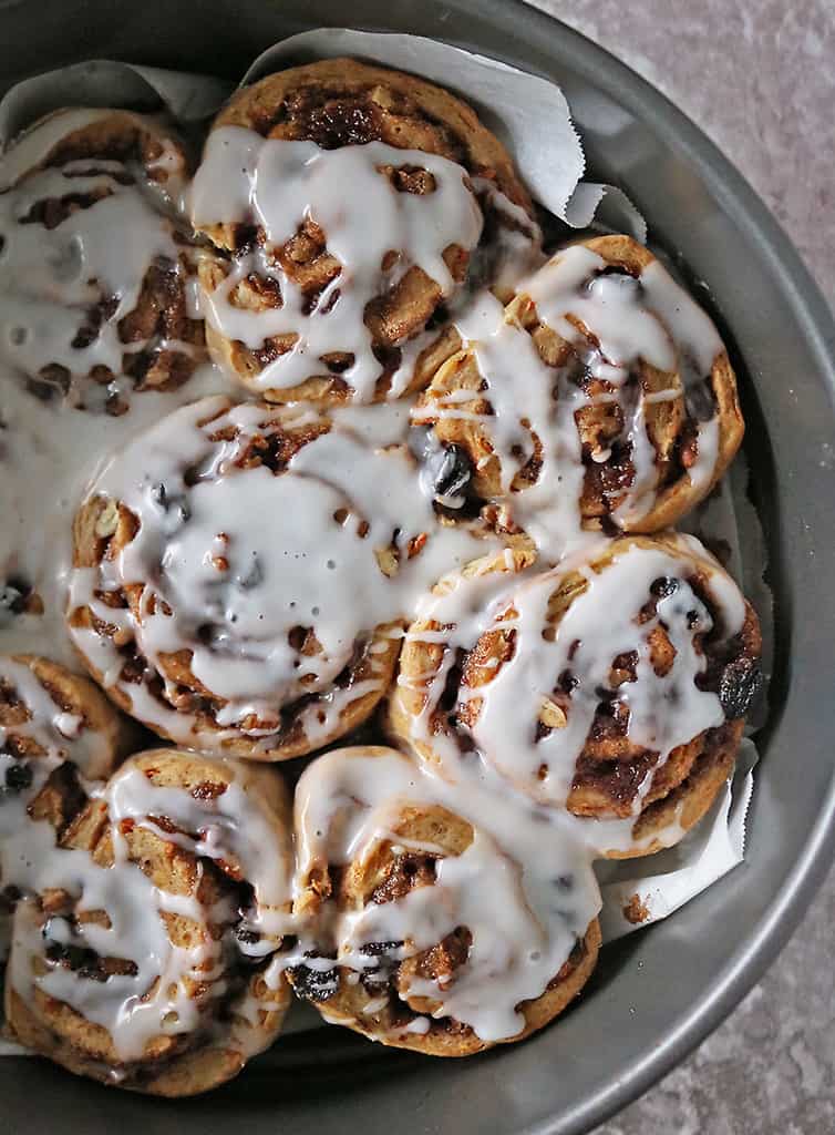 Baking tray with just iced cinnamon rolls.