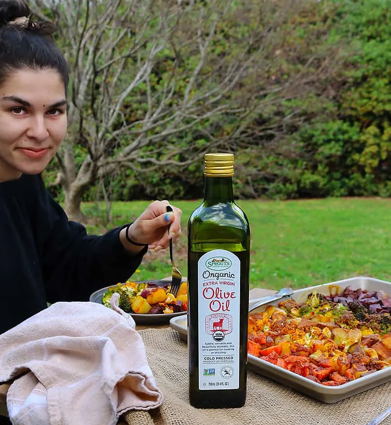 photo of Geri enjoying Earth Day And Sprouts Organic Extra Virgin Olive Oil on a rainbow of roasted veggies in our backyard.