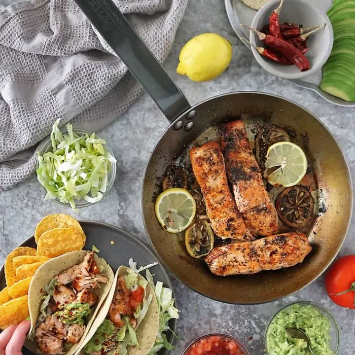 flaky delicious lemon ginger salmon in tacos with gauc and tomatoes
