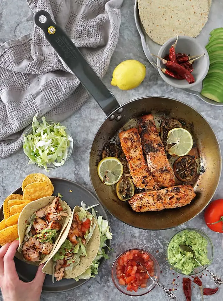 flaky delicious lemon ginger salmon in tacos with gauc and tomatoes