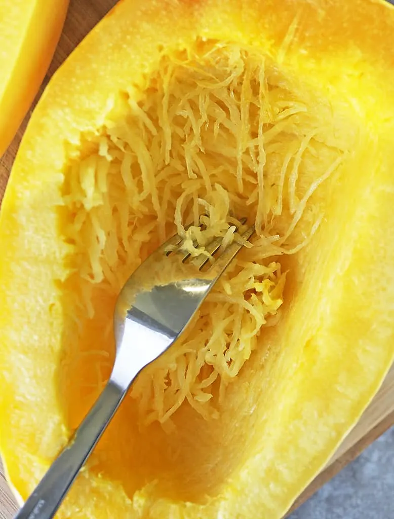 image showing someone using a fork to fluff spaghetti squash