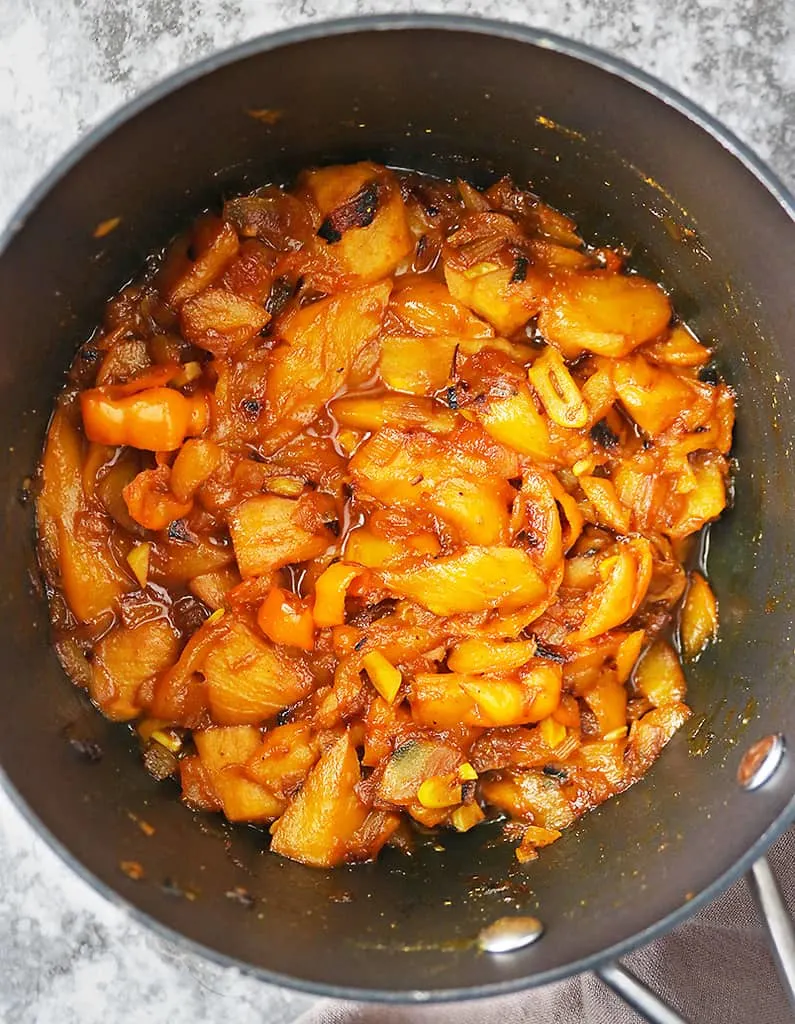 simmering ingredients to make mango habanero chutney in a large pan